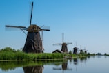a group of windmills sitting on the side of a river
