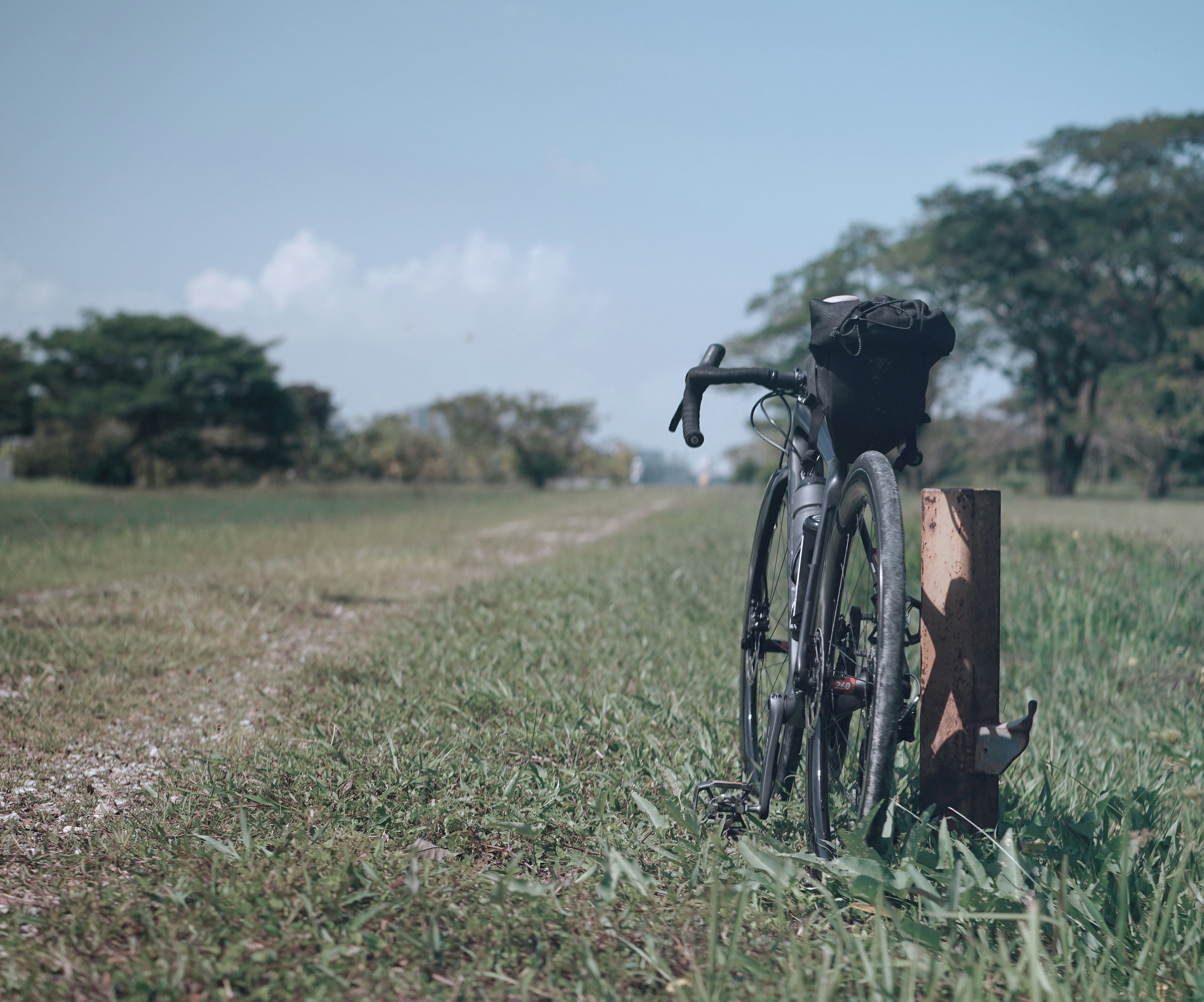 a bike leaning against a post in a field