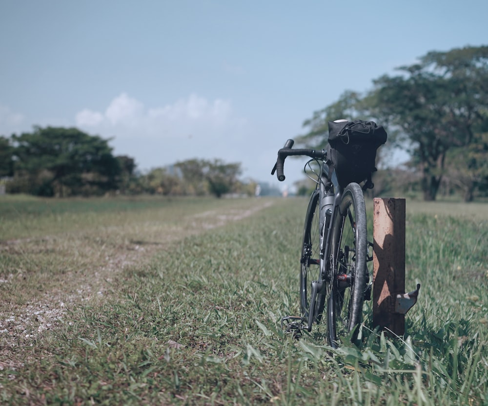 a bike leaning against a post in a field