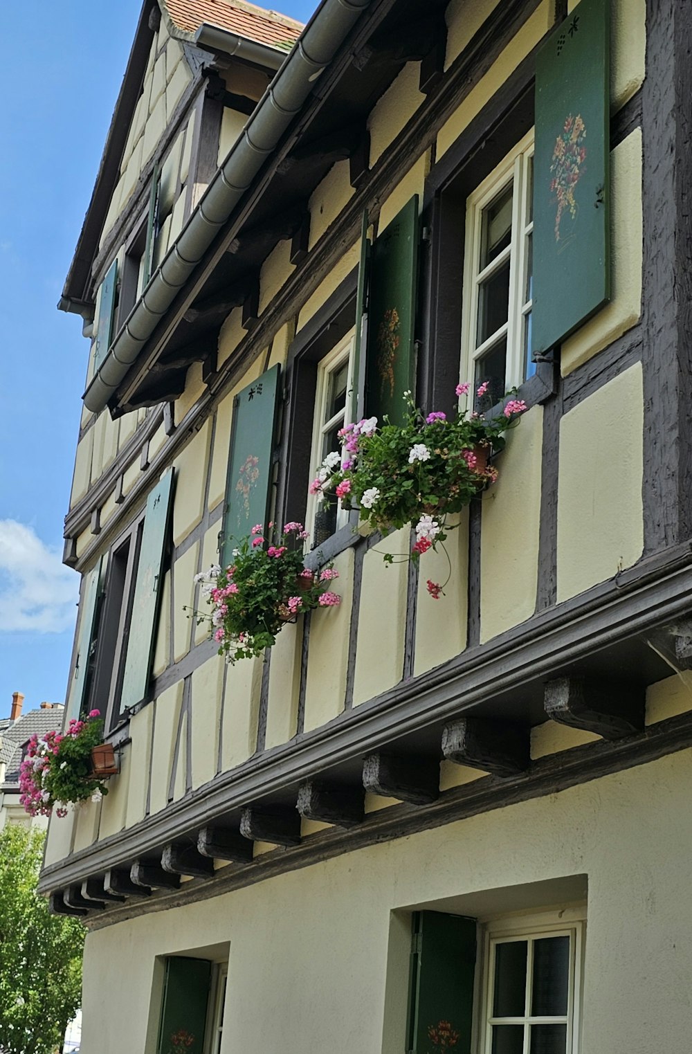 Un bâtiment avec un bouquet de fleurs dans les boîtes de fenêtre