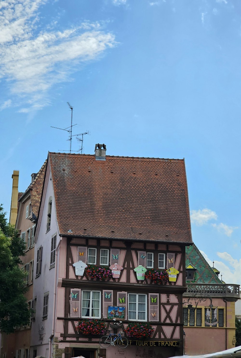 a pink house with a red roof and a brown roof