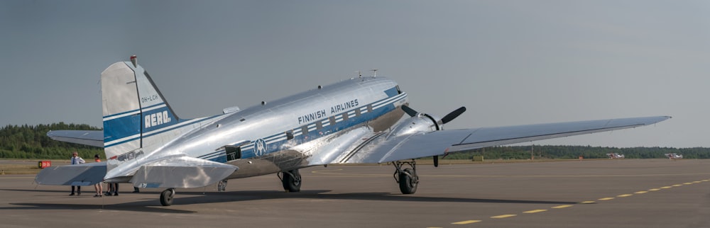 a silver airplane sitting on top of an airport tarmac