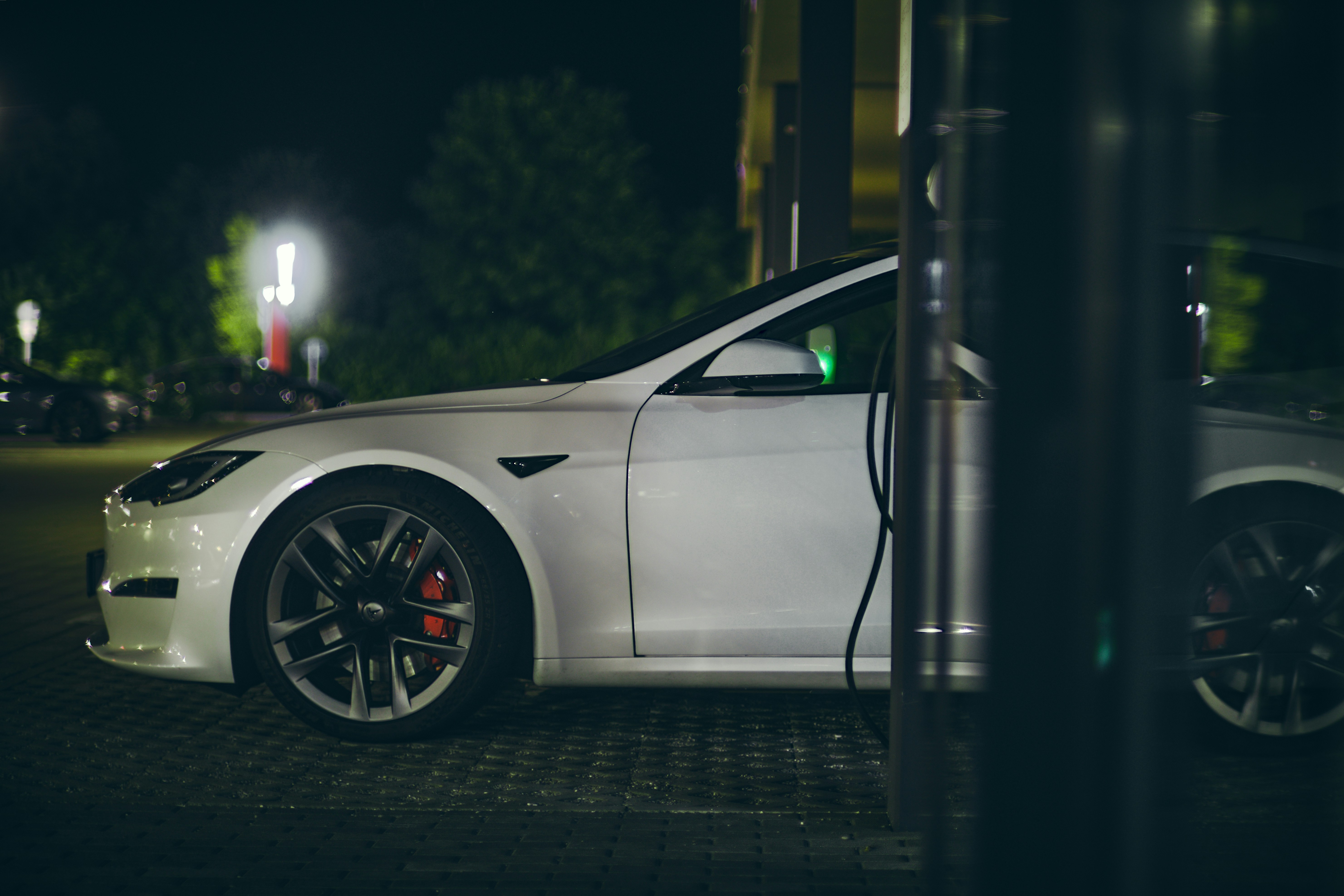 a white car parked in a parking lot at night, 