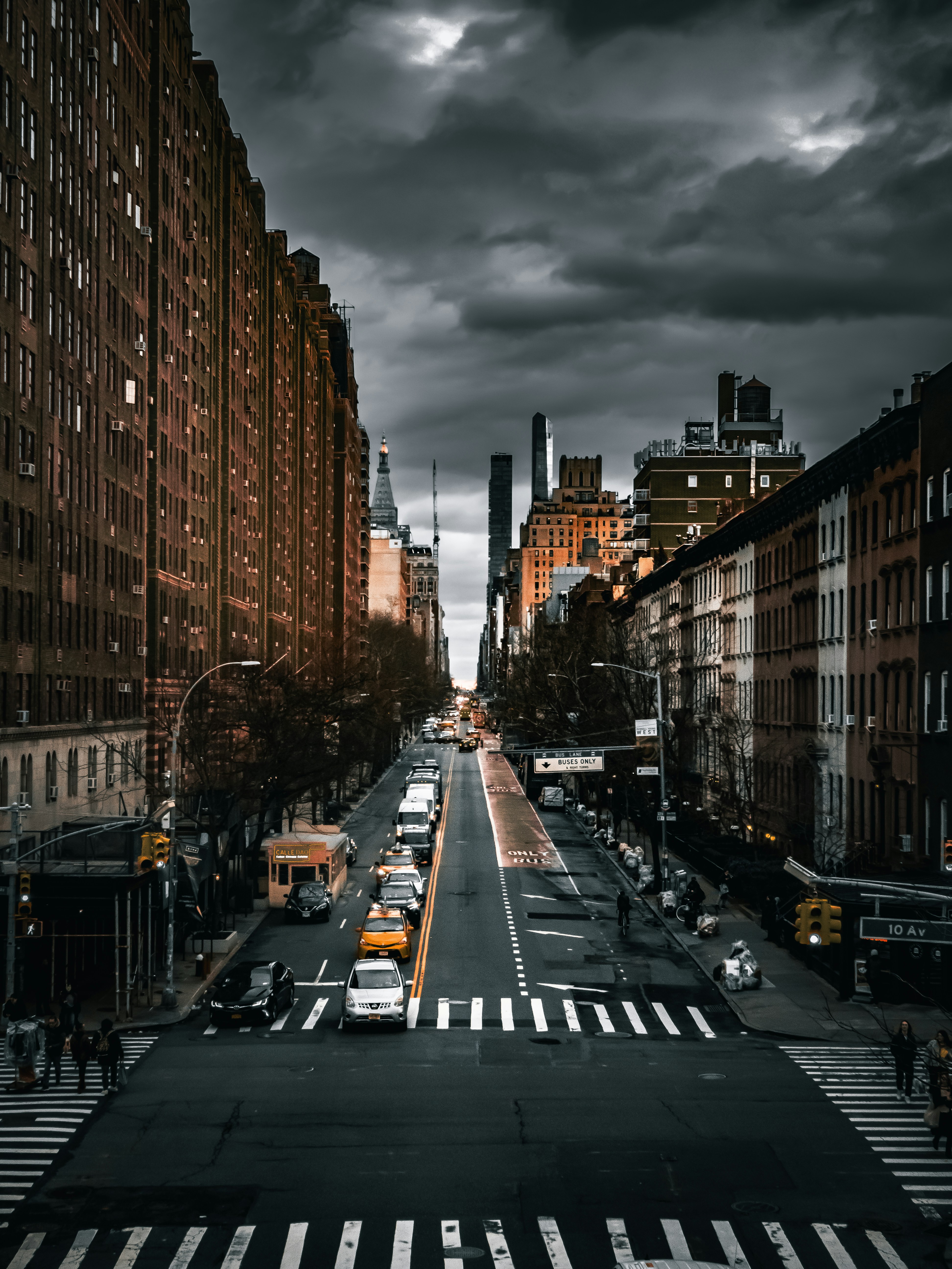 a city street filled with lots of traffic under a cloudy sky