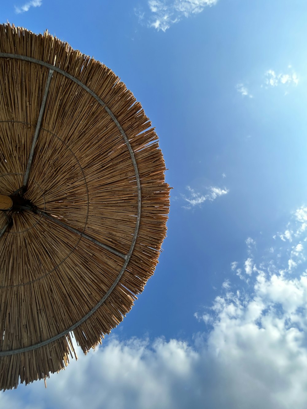 a straw umbrella with a blue sky in the background