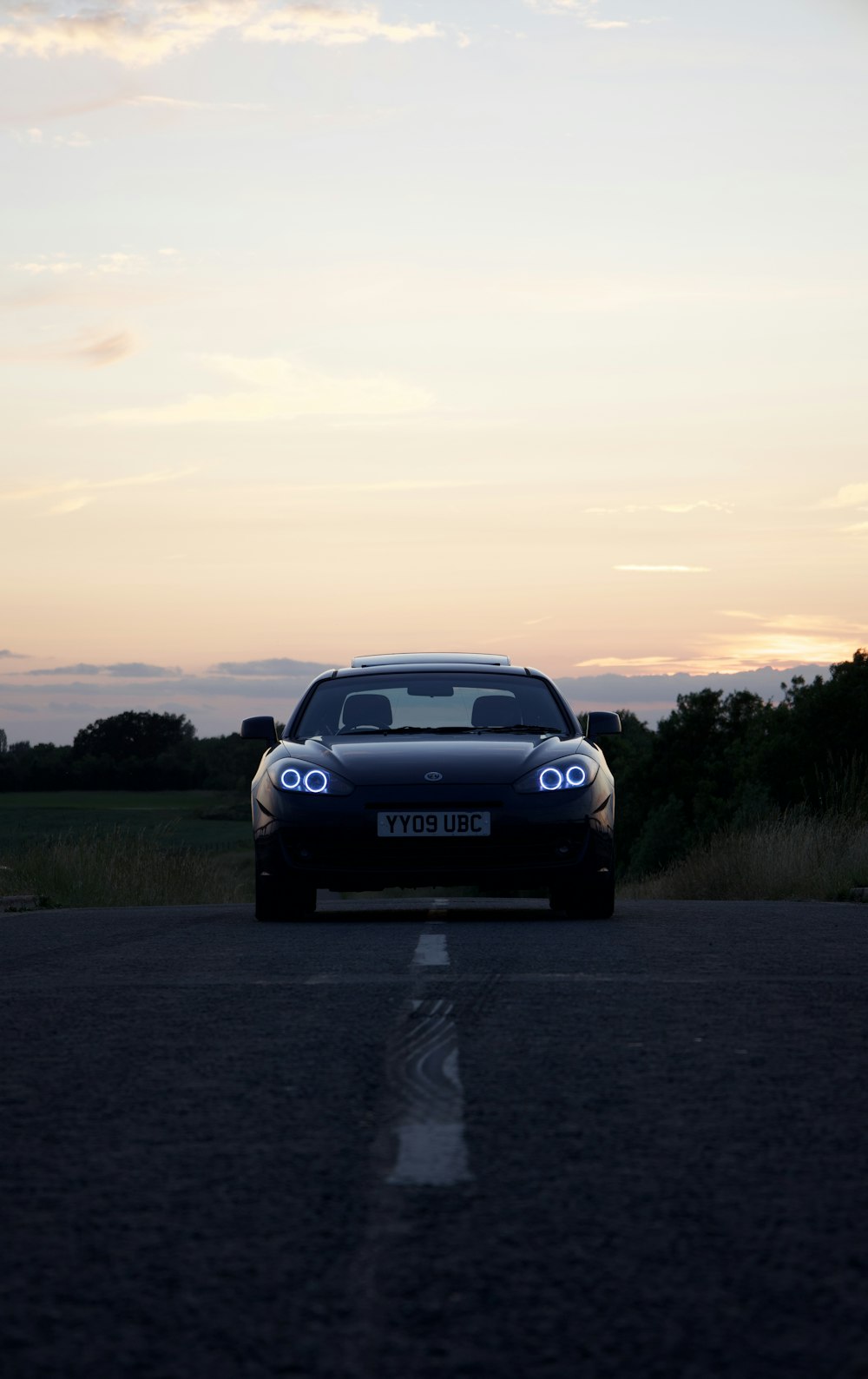 a car driving down the road at dusk