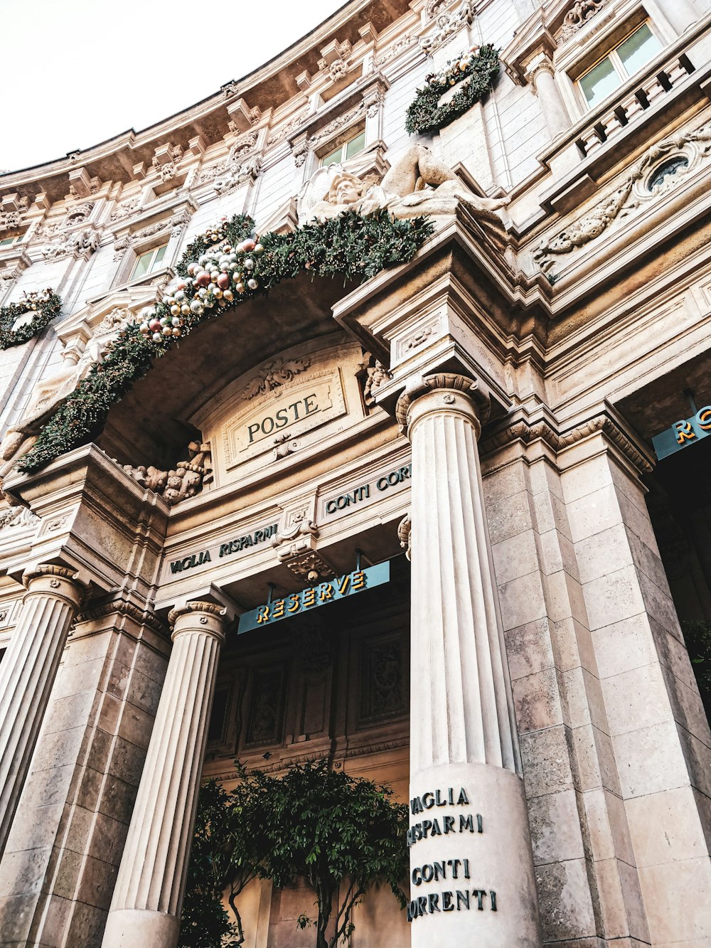 a tall building with columns and flowers on it