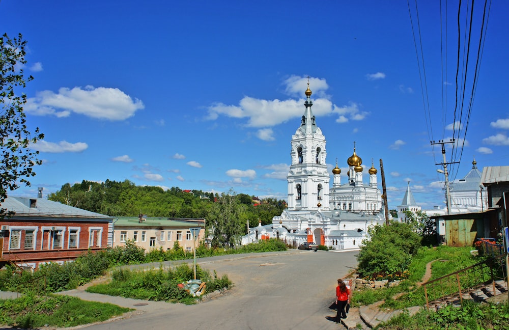 a woman walking down a street in front of a church