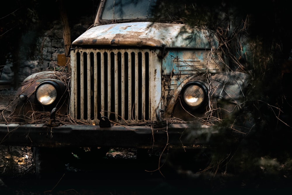 an old rusty truck is sitting in the woods
