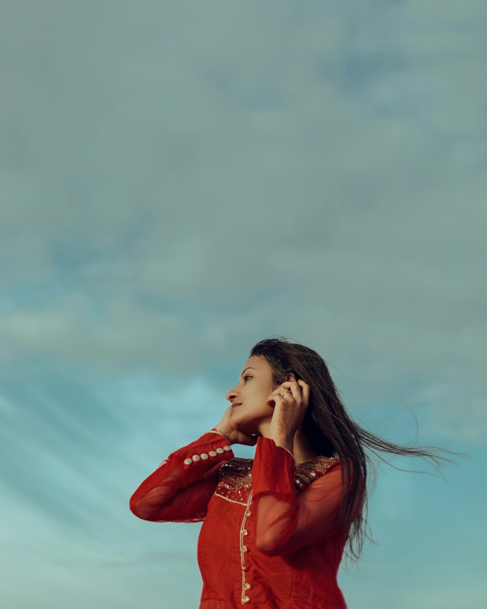 a woman in a red dress talking on a cell phone