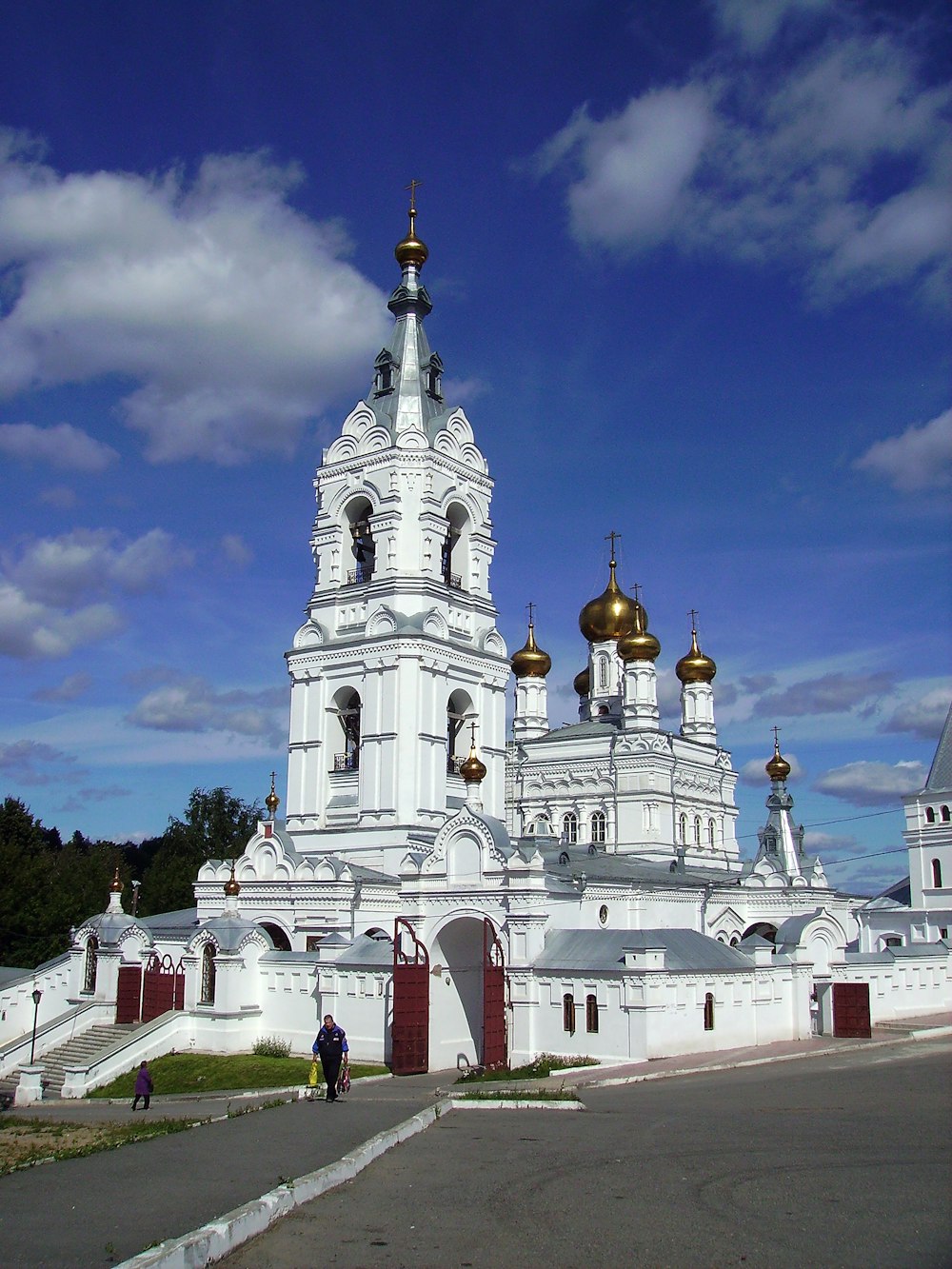 a large white building with gold domes under a blue sky