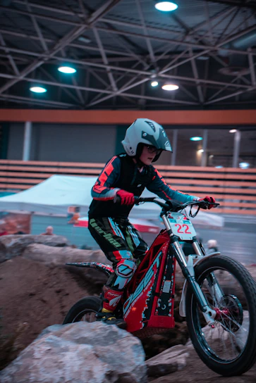 A rider wearing technical indoor gear confidently navigating a winding trail inside a modern facility.