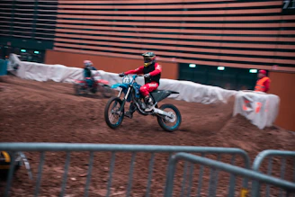 A rider practicing tight turns on a pitbike inside an indoor training facility.