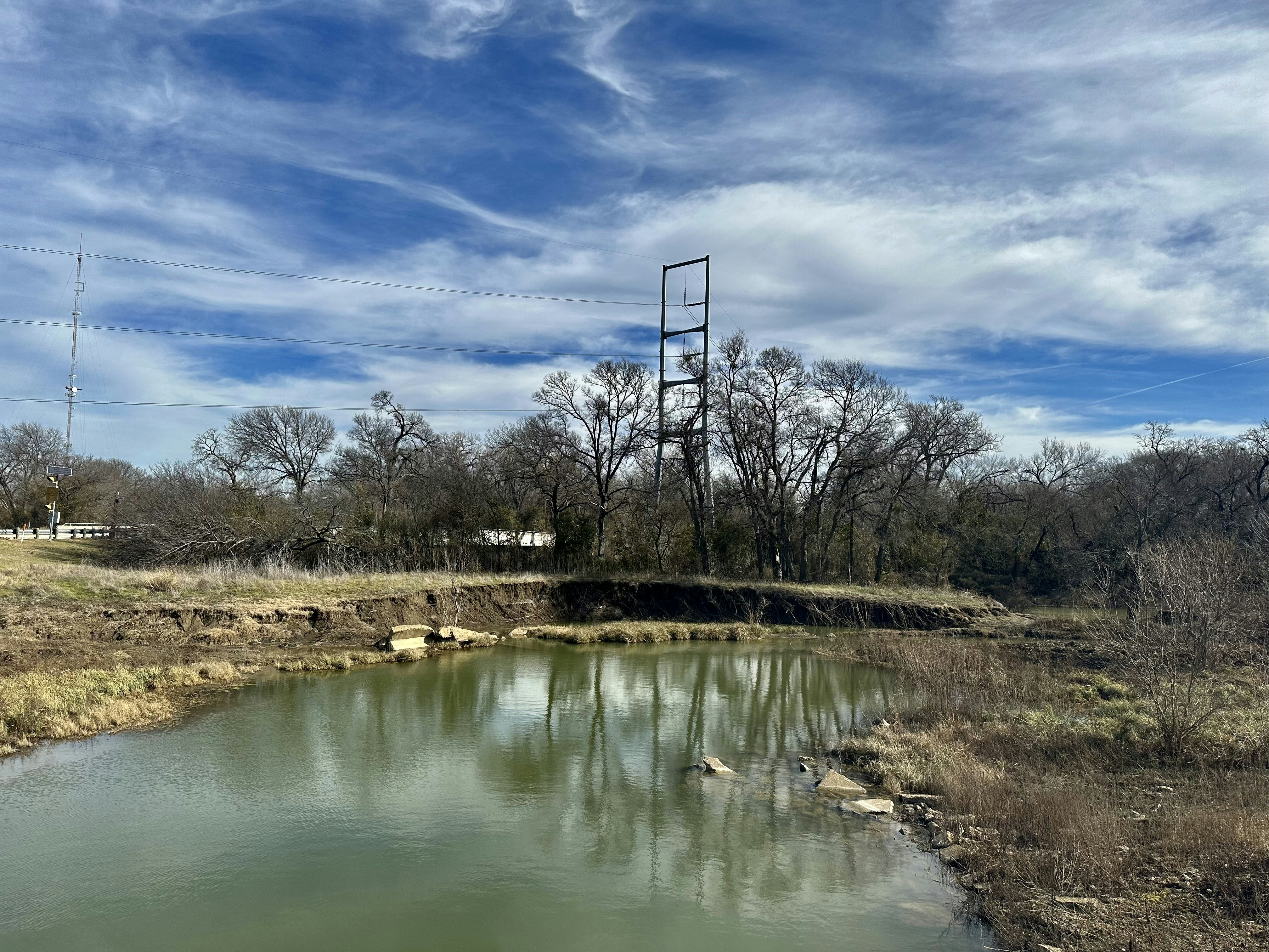 a large body of water sitting next to a dry grass field