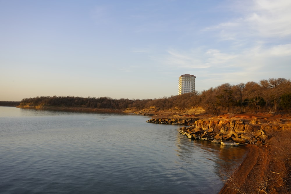 a large body of water with a tall building in the background