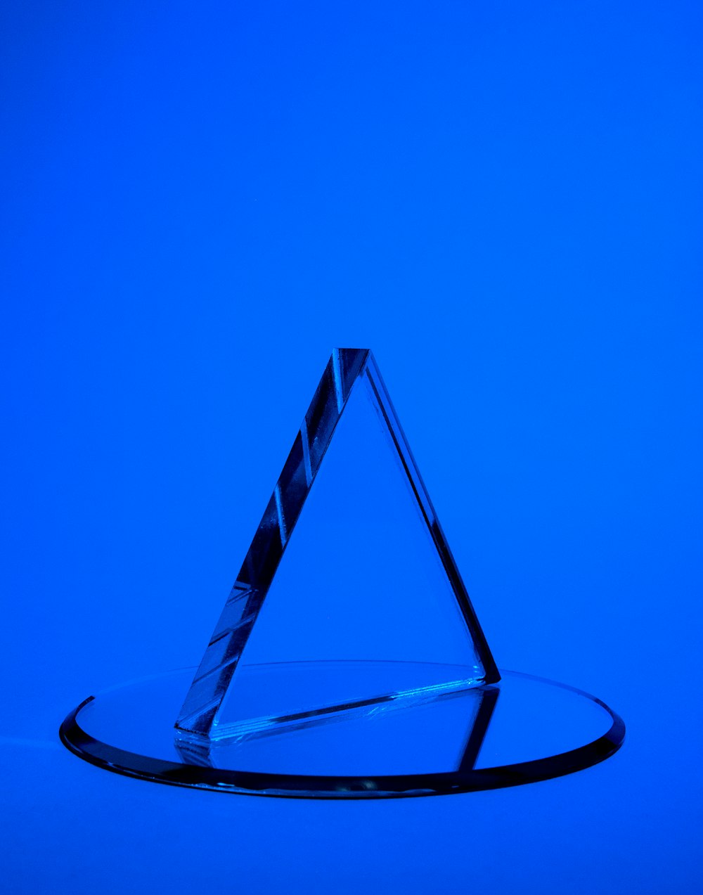 a clear glass triangle on a blue background