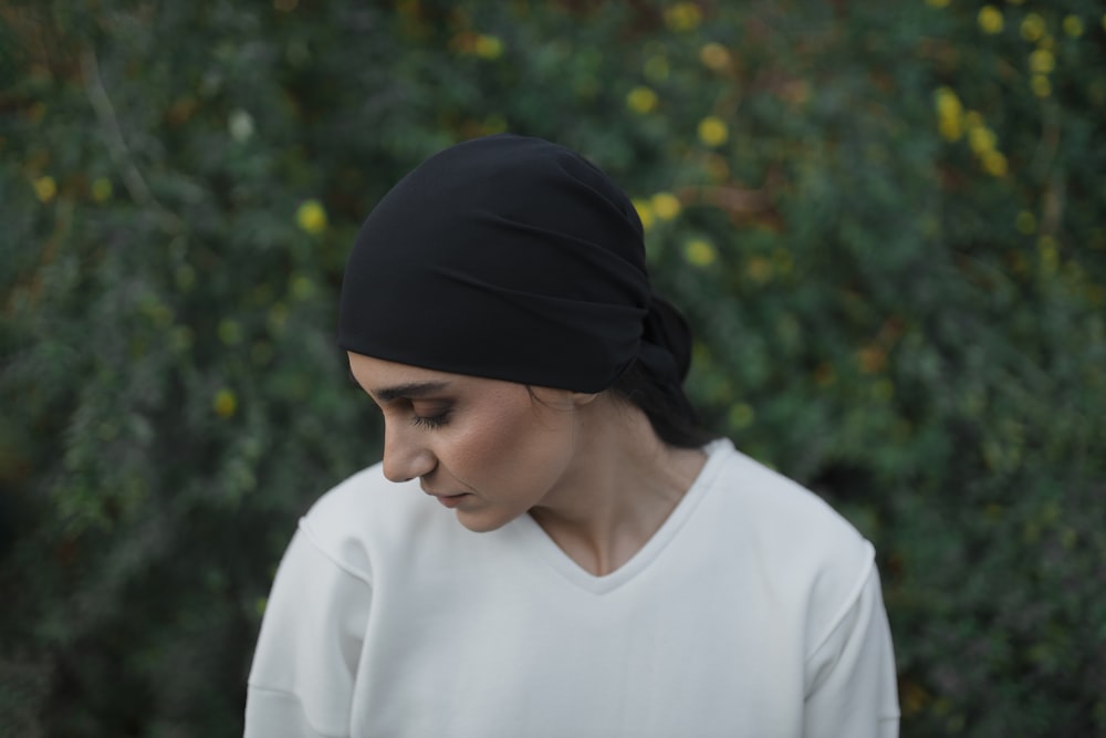 a woman wearing a white shirt and a black turban