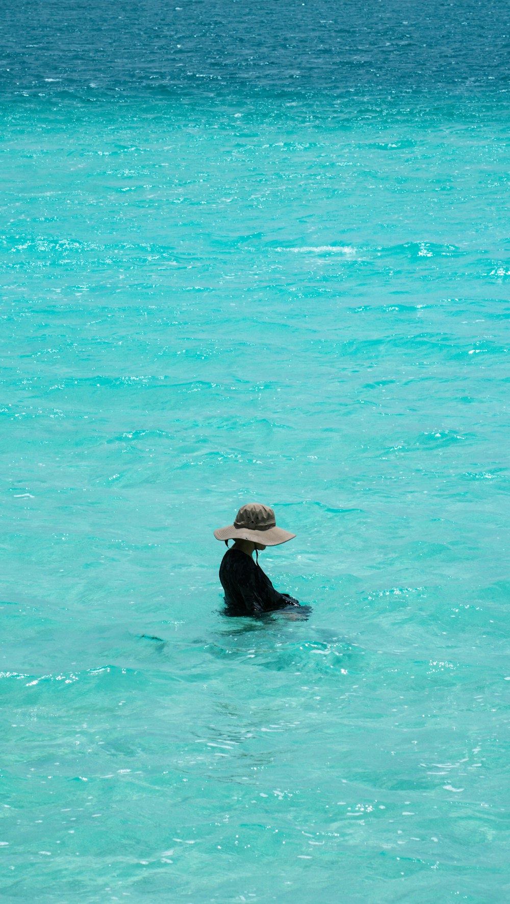 a person in the water wearing a hat