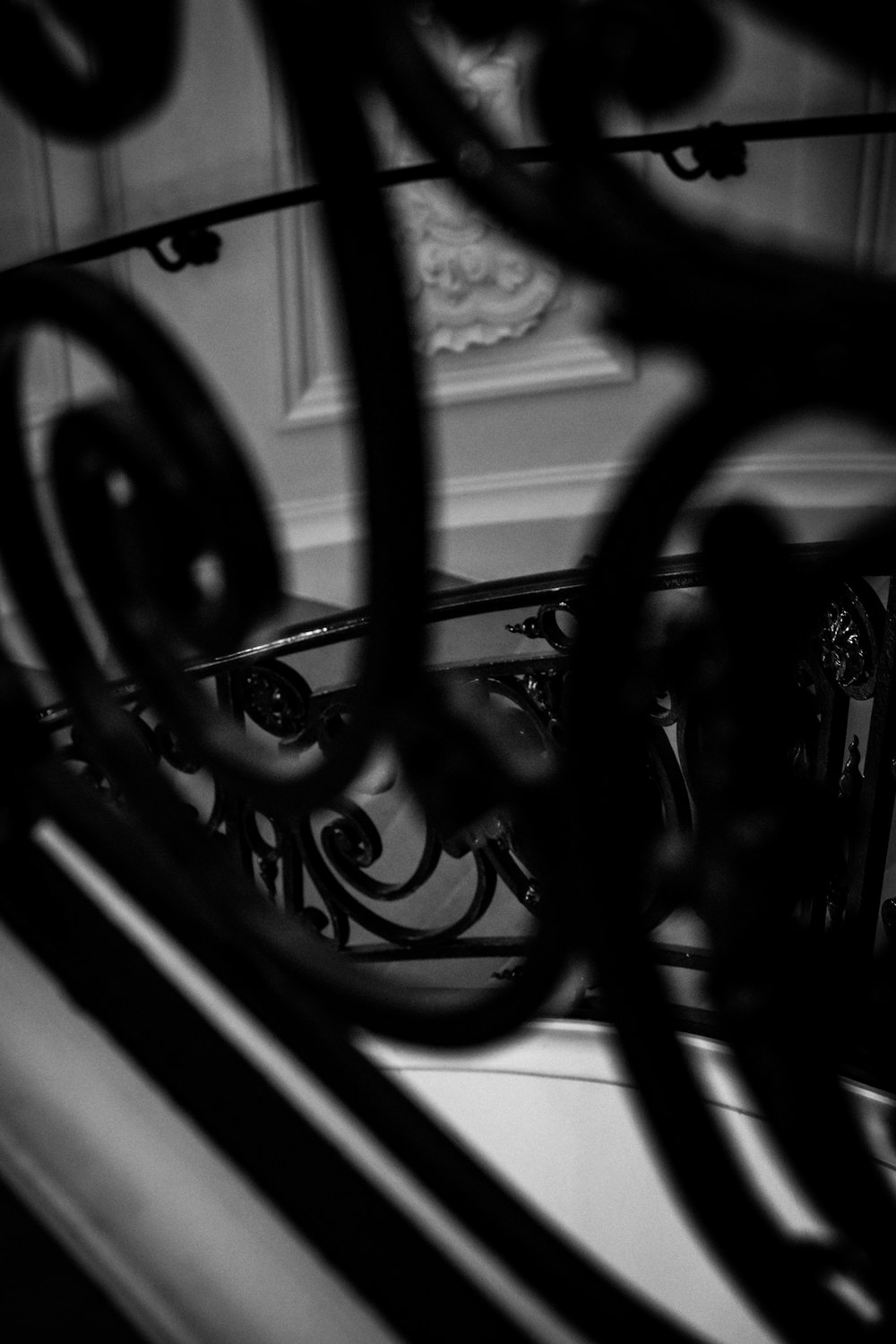 a black and white photo of a wrought iron railing