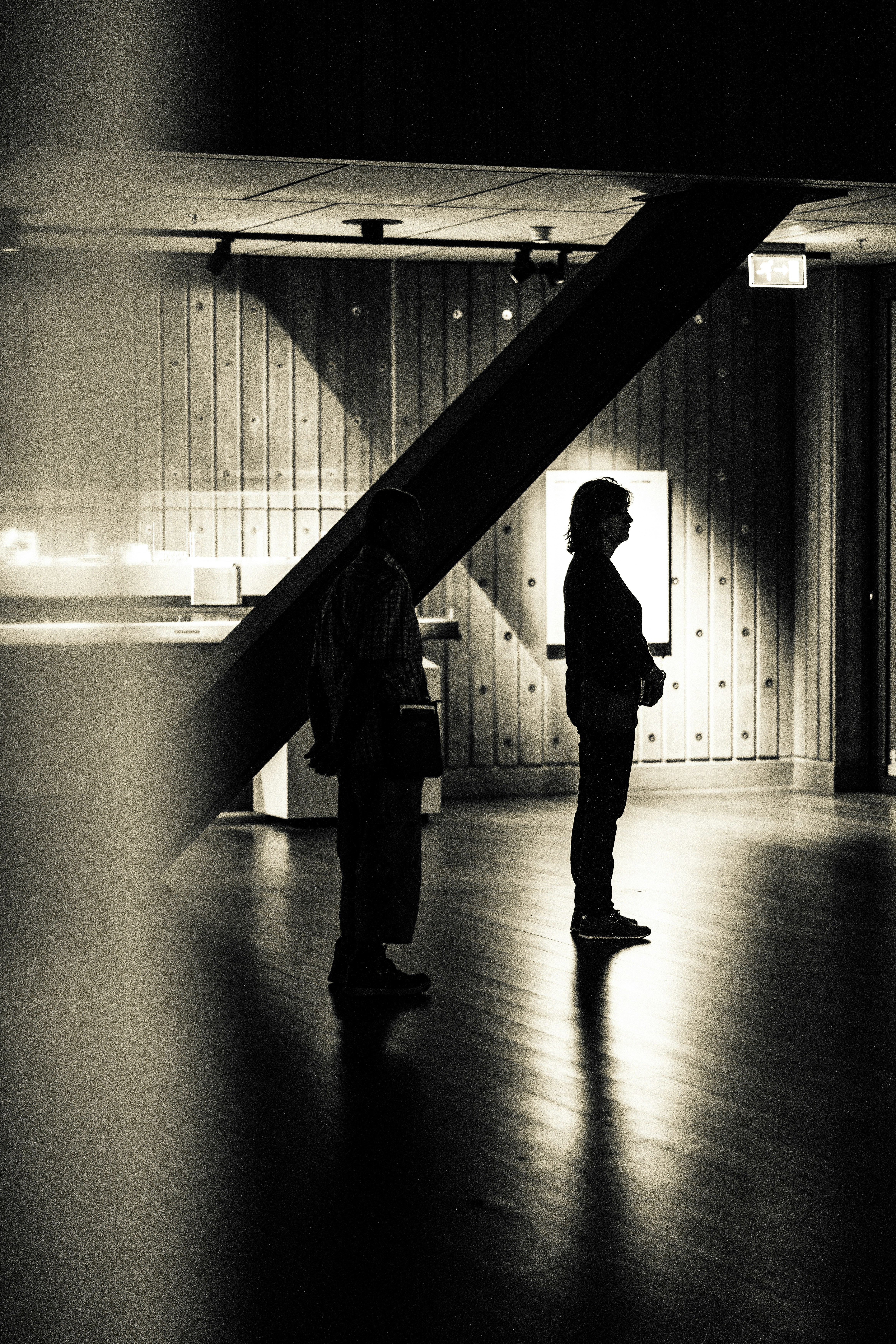a couple of people standing on top of a hard wood floor