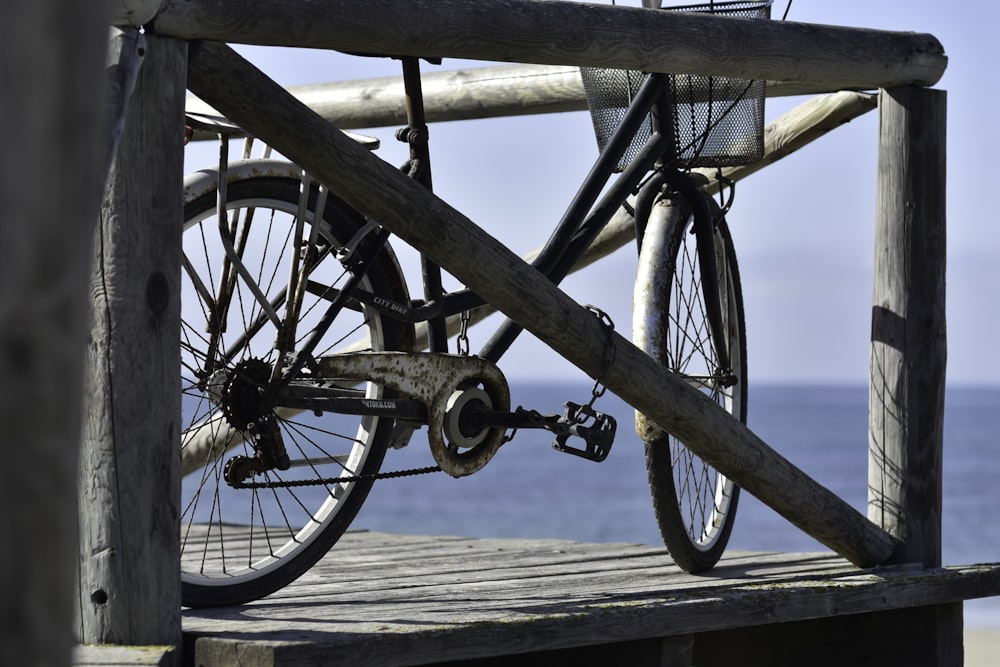 a bicycle parked on a wooden dock near the ocean