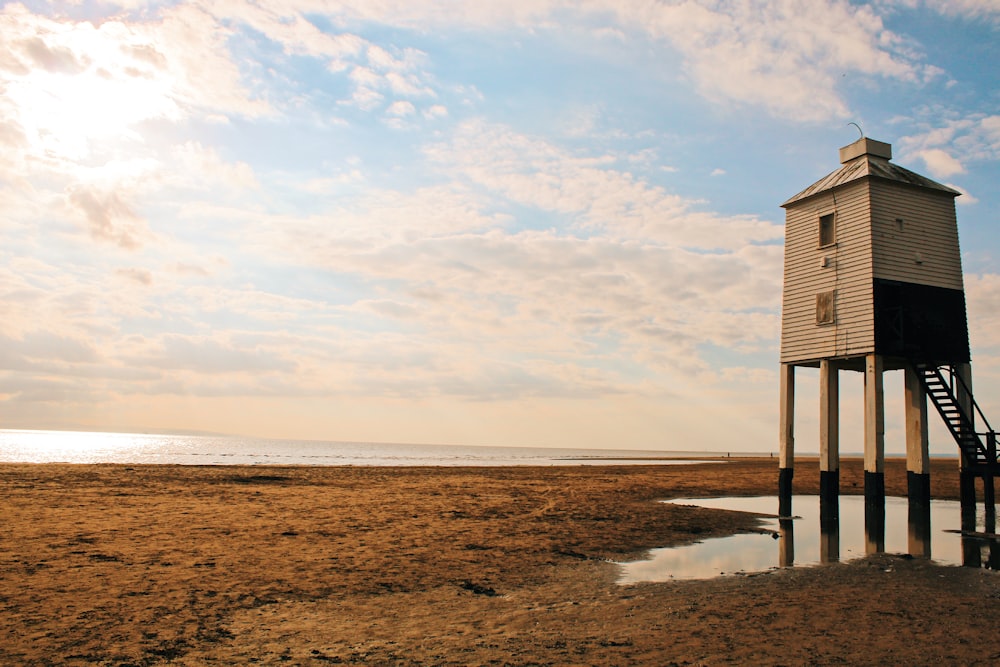 a small tower sitting on top of a sandy beach