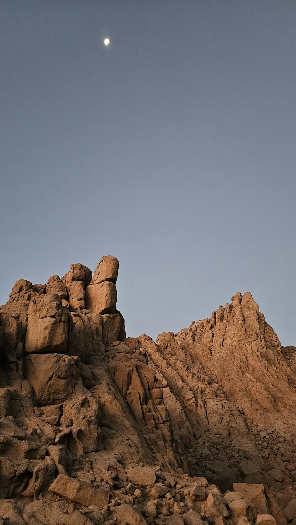 Une pleine lune se levant sur une chaîne de montagnes rocheuses