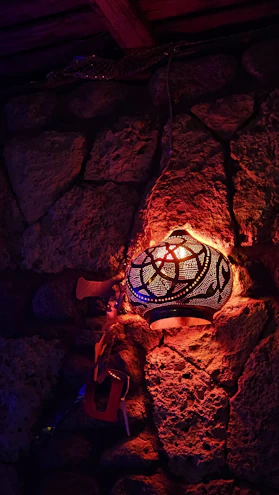 A warm terracotta-toned Moroccan metal lantern glowing softly in a cozy living room corner.