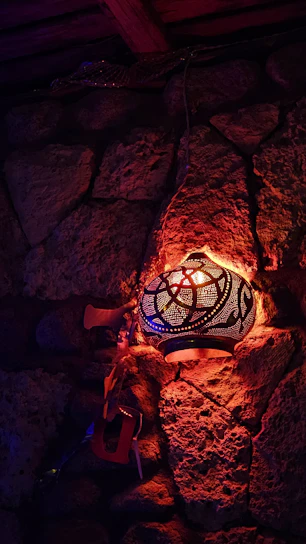 A cozy living room corner featuring a vibrant vintage Moroccan rug and a softly glowing brass lantern.