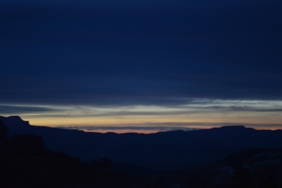 Evening view of the mountains silhouetted against a colorful twilight sky.