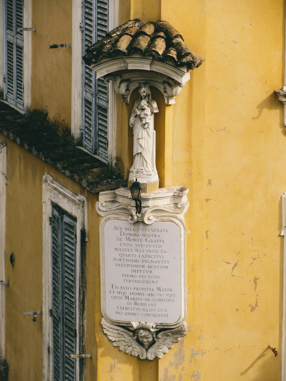 a plaque on the side of a yellow building