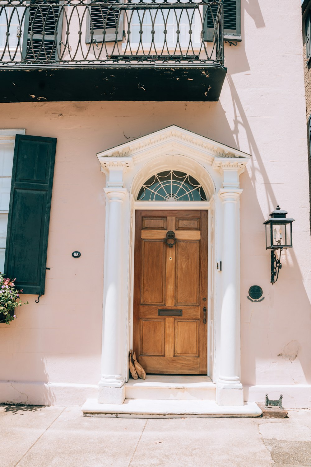 a pink building with a wooden door and window