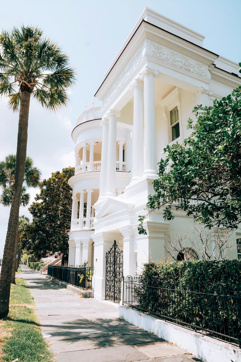 a large white house with a tall palm tree in front of it