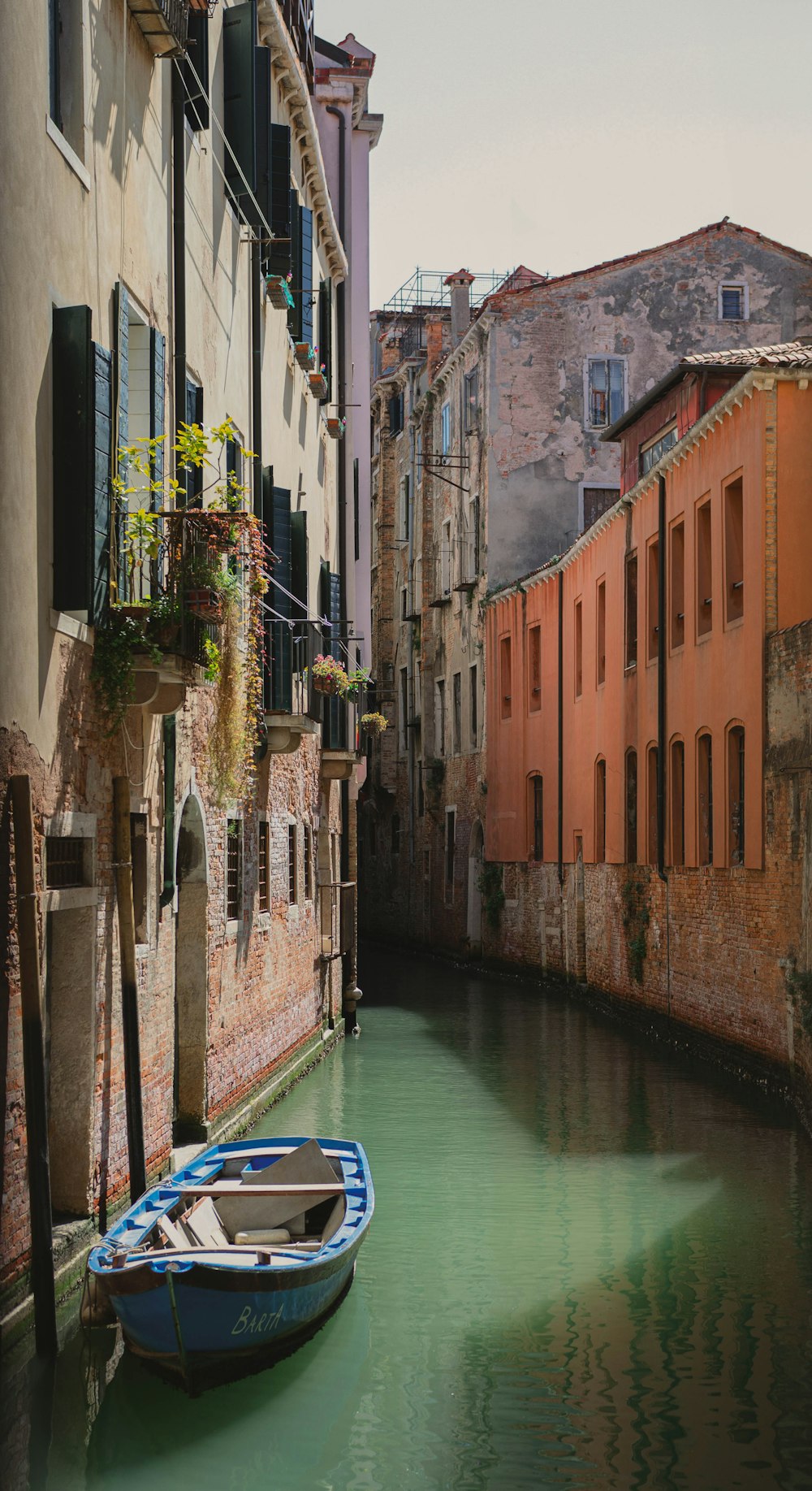 a small boat in a narrow canal between two buildings