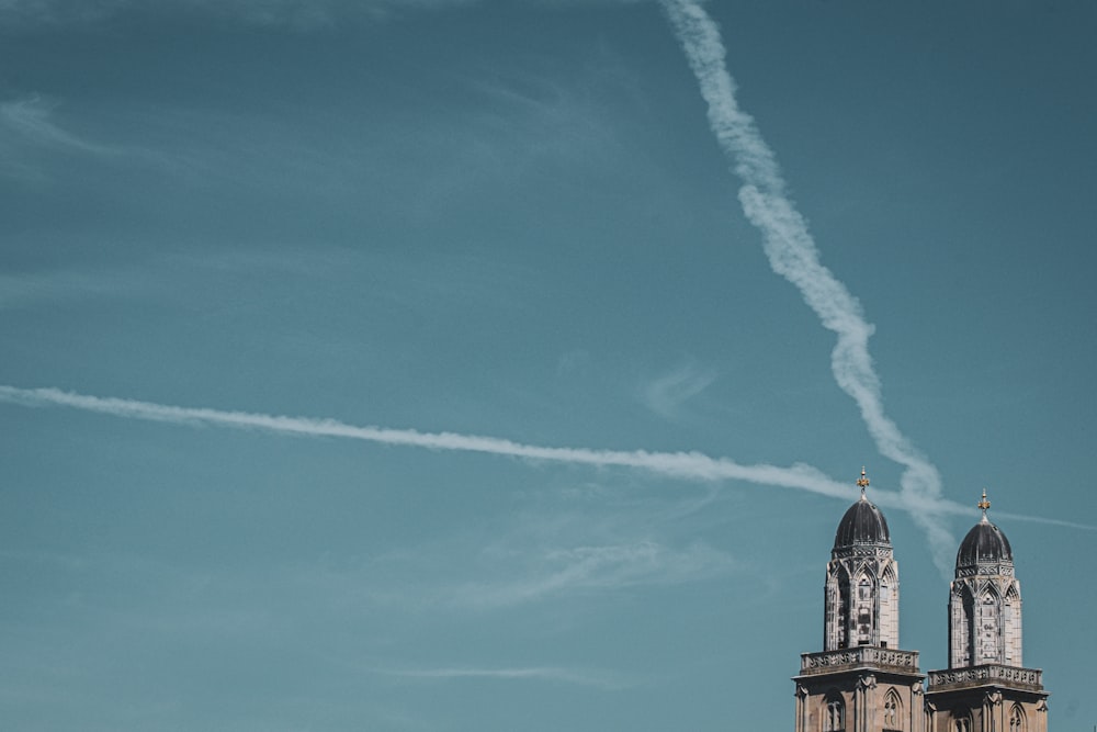 a plane flying in the sky with a contrail behind it