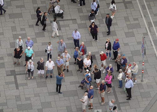 Group of diverse travelers using mobility aids exploring a vibrant city market together.