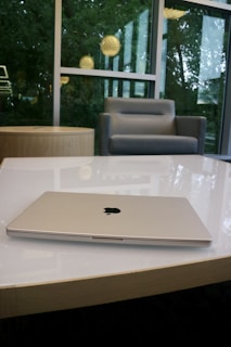 Brand-new Apple MacBook open on a white table with soft natural light