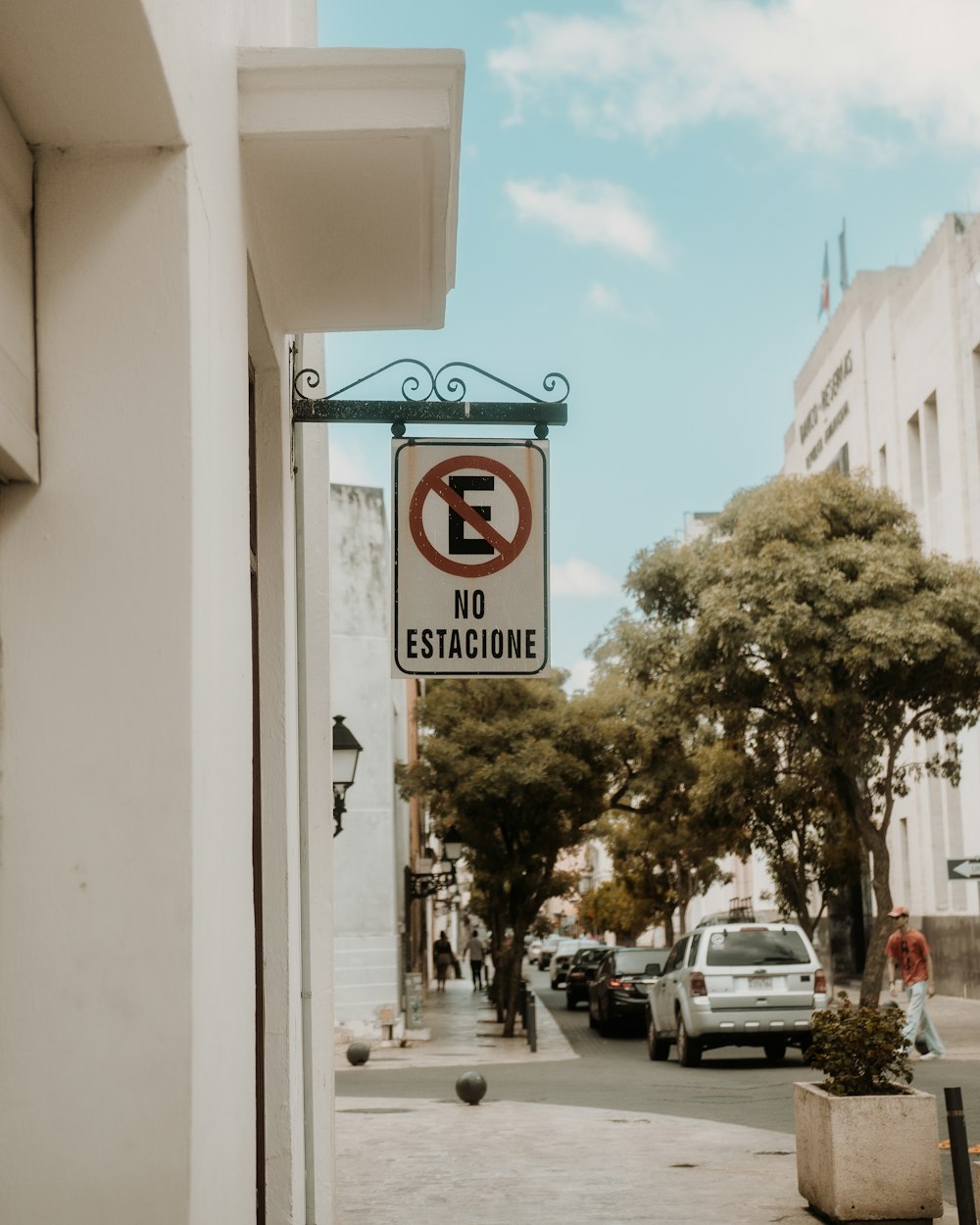 a no parking sign hanging from the side of a building