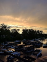 A panoramic view of several inshore boats docked at a marina during golden hour.