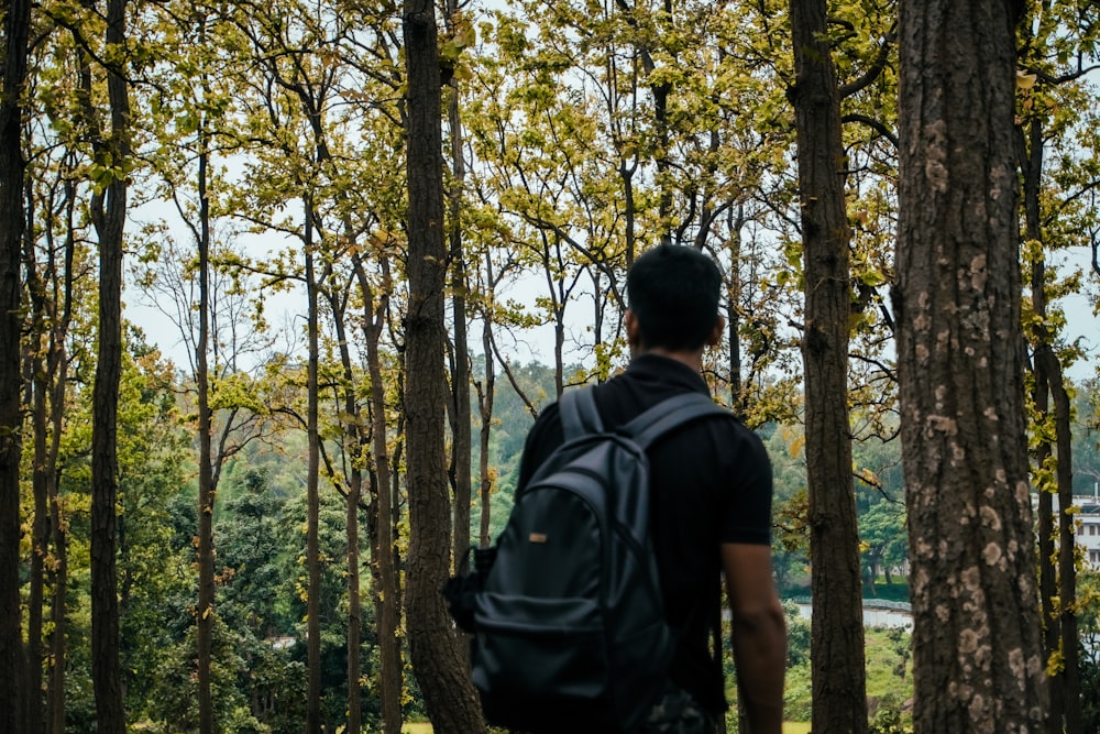 a man with a backpack standing in the woods