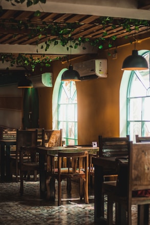 Cozy interior of Tattershall Castle Cafe with rustic wooden tables and sunlight streaming through windows.