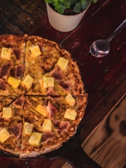 a pizza sitting on top of a wooden table