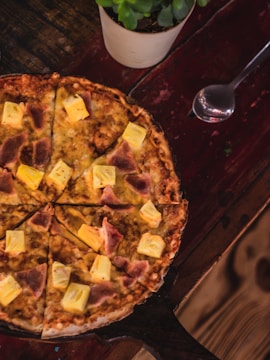 a pizza sitting on top of a wooden table