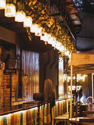 A cozy restaurant interior with warm lighting and a pizza oven glowing in the background.