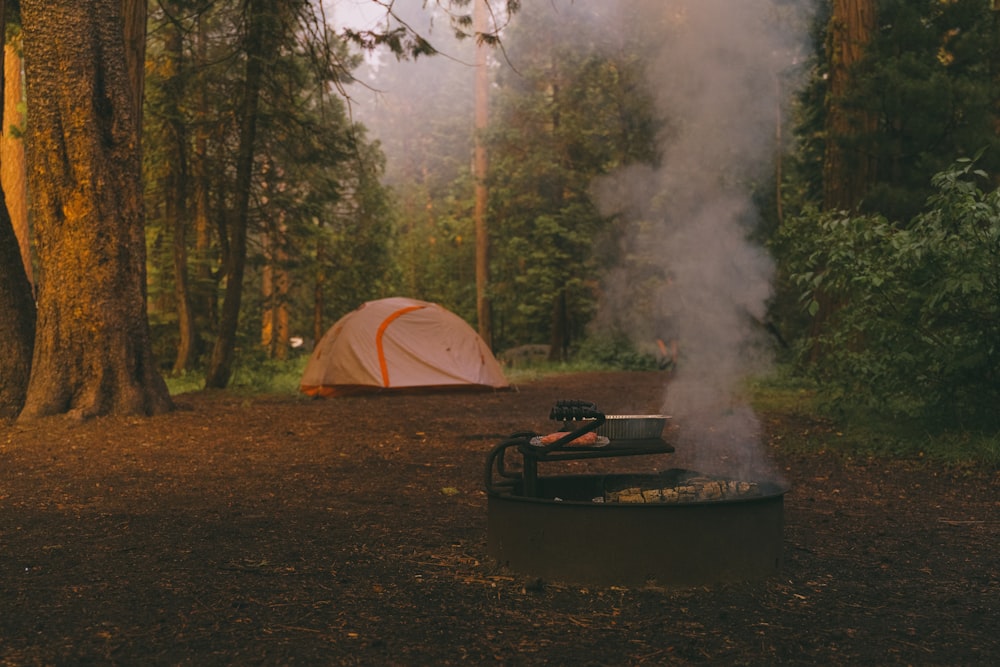 a campfire with a tent in the background