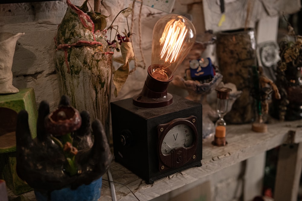 a clock sitting on top of a shelf next to a lamp