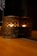 Close-up of a handcrafted wooden tea light candle holder glowing softly on a rustic table.