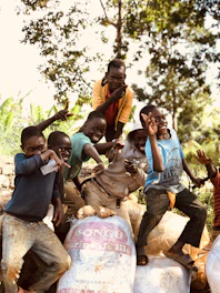 A cheerful school photographer capturing a group of children smiling outdoors.