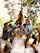 A candid photo of a summer camp group with Oguz smiling and interacting with children outdoors.