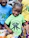 A happy child holding a green owl mascot snack package with a bright smile.